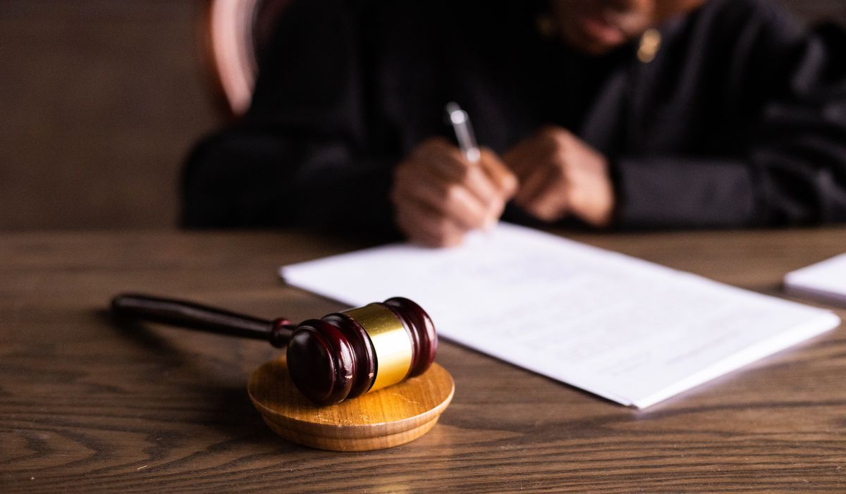 mazo de juez y firma de una querella penal