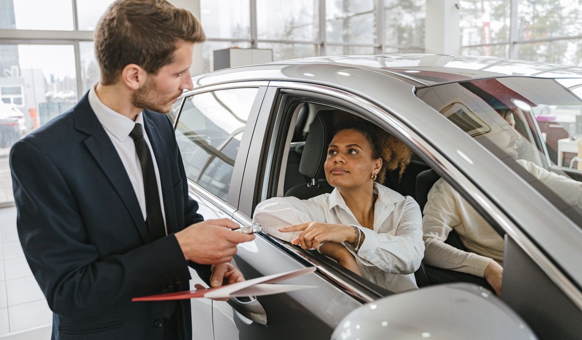 Concesionario entregando un coche nuevo ya matriculado