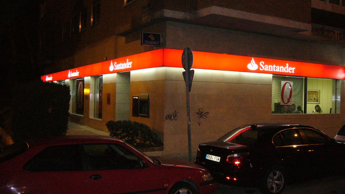 Sucursal del Banco Santander en Madrid con el rótulo rojo iluminado, el banco que deberá devolver 30.000 euros a una pensionista estafada por teléfono